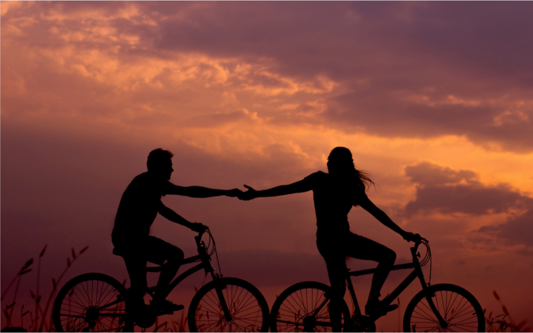 Cyclists holding hands